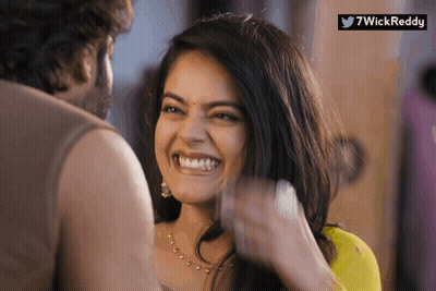 A Woman Is Smiling While A Man Looks On And A Twitter Logo Is Visible GIF