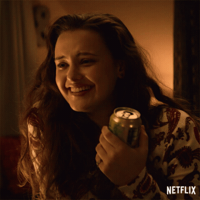 A Woman Is Smiling While Holding A Can Of Soda And A Netflix Logo Is Visible Behind Her GIF