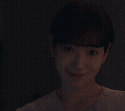 A Woman Is Smiling While Holding A Knife With A Purple Light On It GIF