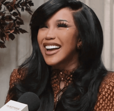 A Woman Is Smiling While Holding A Microphone That Says Aspire GIF