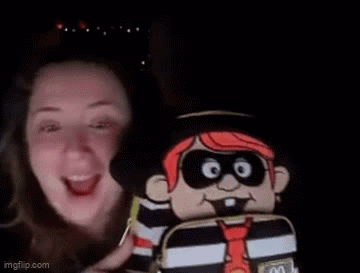 A Woman Is Smiling While Holding A Stuffed Pirate Doll . GIF