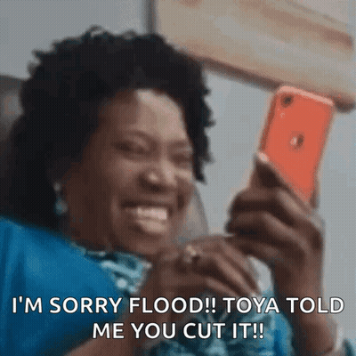 A Woman Is Smiling While Looking At Her Cell Phone And Says I 'M Sorry Flood ! GIF