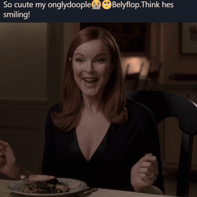 A Woman Is Smiling While Sitting At A Table With A Plate Of Food Behind Her GIF