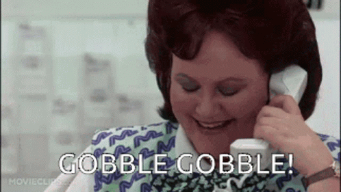 A Woman Is Smiling While Talking On A Cell Phone And The Words Gobble Gobble Are Visible . GIF