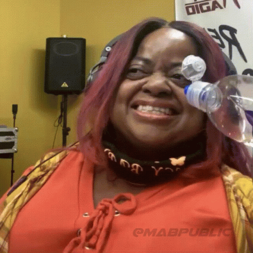 A Woman Is Smiling With A Bottle Of Water In Front Of Her Face GIF