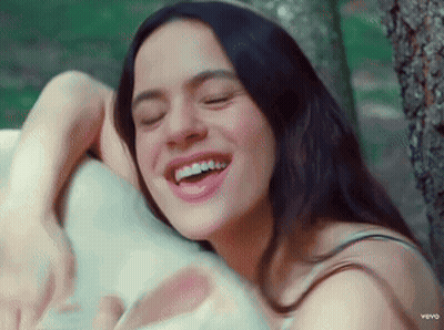 A Woman Is Smiling With Her Eyes Closed And Her Teeth Showing GIF