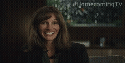 A Woman Is Smiling With #Homecomingtv Written Above Her GIF