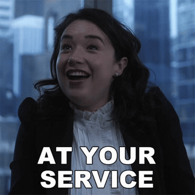 A Woman Is Smiling With The Words At Your Service Written Below Her GIF