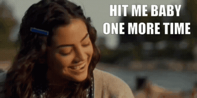 A Woman Is Smiling With The Words Hit Me Baby One More Time Behind Her . GIF