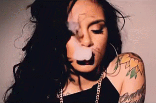 A Woman Is Smoking A Cigarette With A Tattoo On Her Arm . GIF