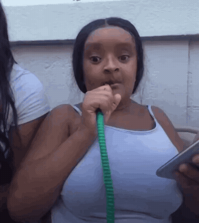 A Woman Is Smoking A Hookah While Holding A Cell Phone GIF