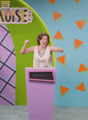 A Woman Is Standing Behind A Podium With The Name Anna On It GIF