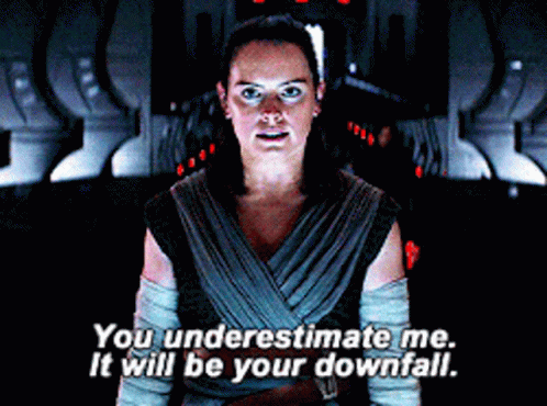 A Woman Is Standing In A Dark Room And Saying You Underestimate Me It Will Be Your Downfall GIF