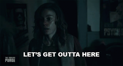 A Woman Is Standing In A Dark Room And Says Let 'S Get Outta Here GIF