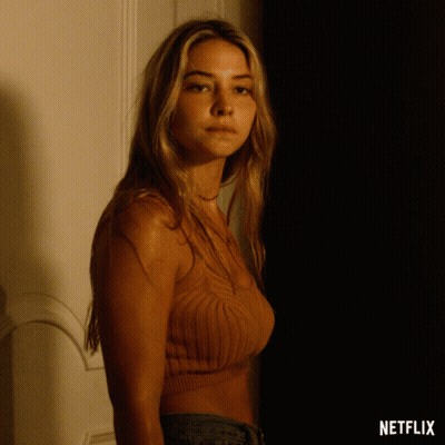 A Woman Is Standing In A Dark Room With A Netflix Logo On The Bottom GIF