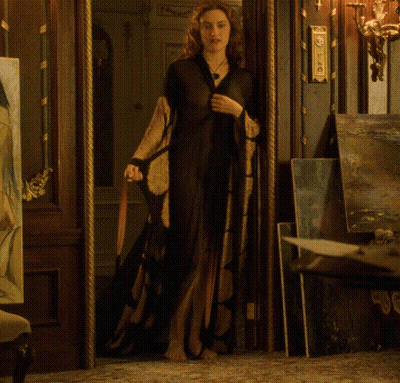 A Woman Is Standing In A Doorway With A Clock On The Wall That Says ' Clock ' On It GIF