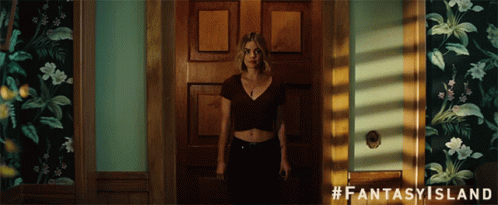 A Woman Is Standing In A Doorway With #Fantasy Island Written On The Bottom GIF