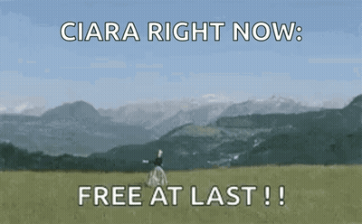 A Woman Is Standing In A Field With Mountains In The Background And The Words " Free At Last " GIF
