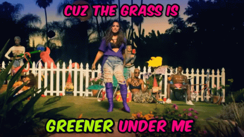 A Woman Is Standing In A Garden With The Words Cuz The Grass Is Greener Under Me On The Bottom GIF