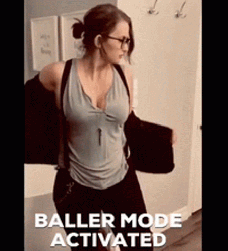A Woman Is Standing In A Hallway With The Words Baller Mode Activated On The Bottom Right GIF