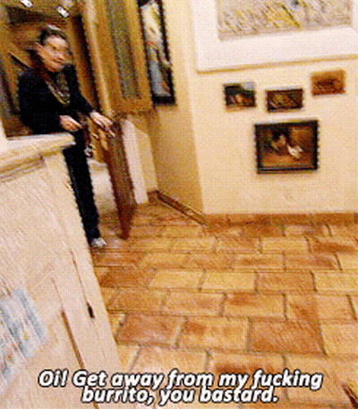A Woman Is Standing In A Hallway With The Words " Get Away From My Fucking Burrito You Bastard " On The Floor GIF