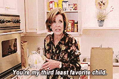 A Woman Is Standing In A Kitchen Holding A Bag Of Food And Talking To Someone . GIF