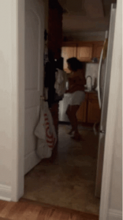 A Woman Is Standing In A Kitchen With A Towel That Says ' I Love You ' On It GIF