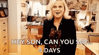 A Woman Is Standing In A Living Room With A Cat And A Man Standing Behind Her . GIF