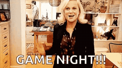 A Woman Is Standing In A Living Room With The Words `` Game Night '' Written On Her Face . GIF