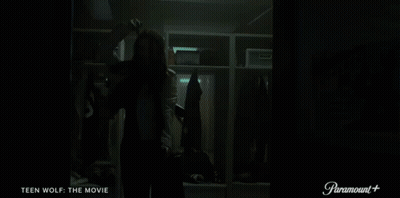 A Woman Is Standing In A Locker Room With The Words Teen Wolf The Movie On The Bottom GIF