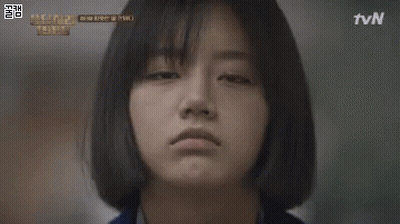 A Woman Is Standing In A Phone Booth With A Sign That Says G. GIF