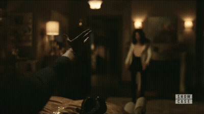 A Woman Is Standing In A Room With A Sign That Says Show Case On It GIF