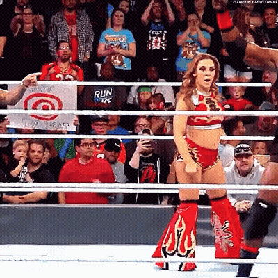 A Woman Is Standing In A Wrestling Ring With A Sign That Says Run GIF
