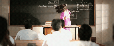 A Woman Is Standing In Front Of A Blackboard That Says R.v. R.h. On It GIF
