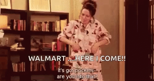 A Woman Is Standing In Front Of A Bookshelf In A Living Room . GIF