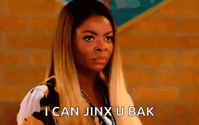 A Woman Is Standing In Front Of A Brick Wall And Says `` I Can Jinx U Bak '' . GIF