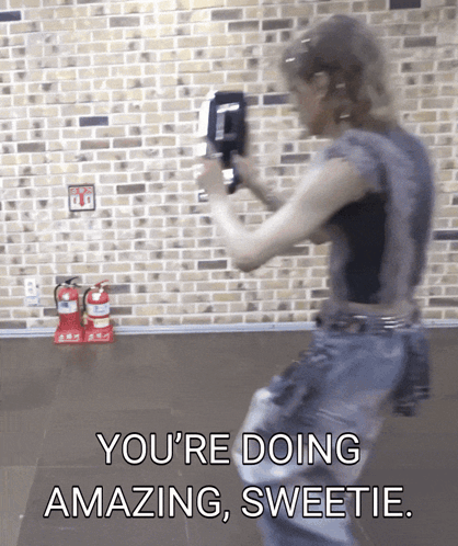 A Woman Is Standing In Front Of A Brick Wall And Says You 'Re Doing Amazing Sweetie GIF