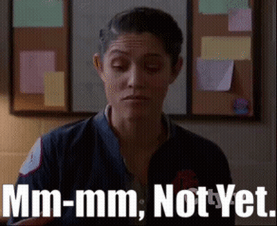 A Woman Is Standing In Front Of A Bulletin Board And Says Mm-Mm Not Yet . GIF