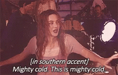 A Woman Is Standing In Front Of A Car With Her Arms Outstretched And Saying In Southern Accent Mighty Cold . GIF