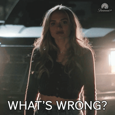 A Woman Is Standing In Front Of A Car With The Words What 'S Wrong Written Below Her GIF
