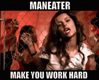 A Woman Is Standing In Front Of A Chain Link Fence With The Words Maneater Make You Work Hard Below Her GIF