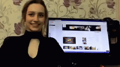 A Woman Is Standing In Front Of A Computer Monitor With A Banner On The Screen That Says " Army " GIF