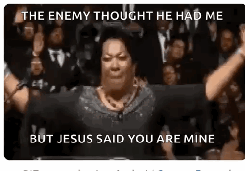 A Woman Is Standing In Front Of A Crowd With Her Hands In The Air . GIF