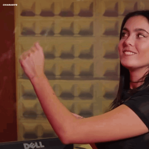 A Woman Is Standing In Front Of A Dell Computer Monitor GIF