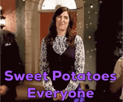 A Woman Is Standing In Front Of A Door With A Sign That Says Sweet Potatoes Everyone GIF
