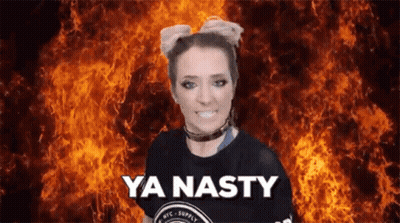 A Woman Is Standing In Front Of A Fire And Says Ya Nasty GIF