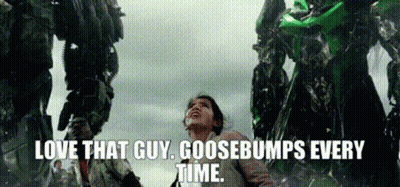 A Woman Is Standing In Front Of A Giant Robot And Says `` Love That Guy Goosebumps Every Time '' . GIF