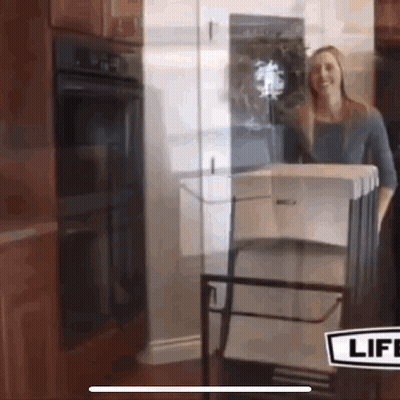 A Woman Is Standing In Front Of A Glass Door With A Sign That Says Life GIF