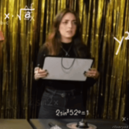 A Woman Is Standing In Front Of A Gold Curtain Holding A Piece Of Paper That Says 2 Sin 52 = 1 GIF