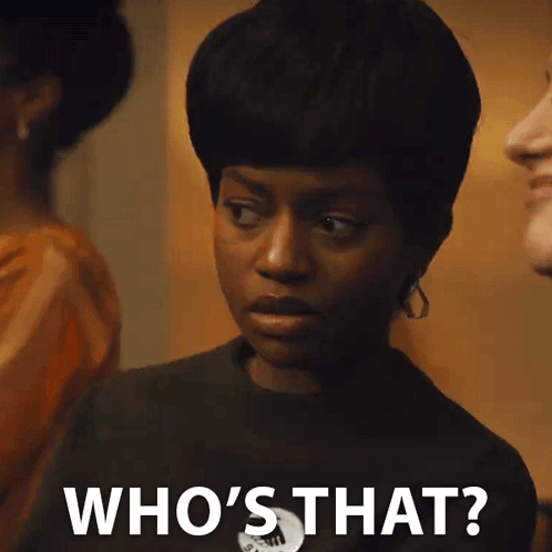 A Woman Is Standing In Front Of A Group Of People And Says Who 'S That ? GIF